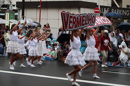 Ragazze danzano con cartello al festival Asakusa Samba Carnival, Tokyo.