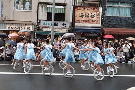 Bambine su monocicli in abiti azzurri durante Asakusa Samba Carnival.
