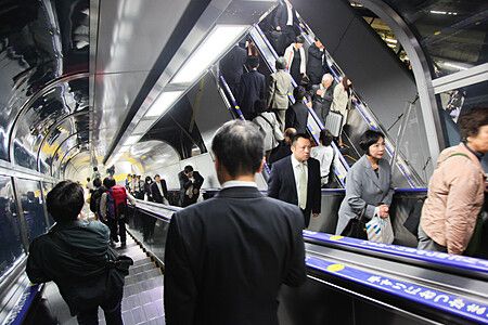 Persone su scale mobili in una stazione in Giappone