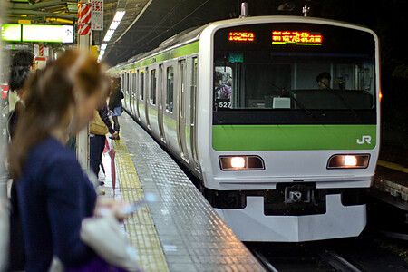 Treno della linea Yamanote in Giappone con una persona sul binario