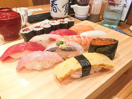 Un vassoio di legno con diversi pezzi di sushi nigiri e maki servito al Tama Sushi a Tachikawa.