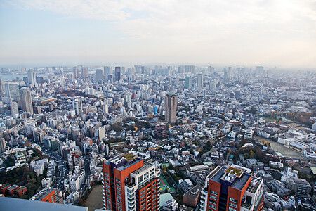 Vista panoramica di Tokyo con numerosi grattacieli e un cielo parzialmente coperto.