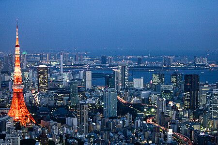 Vista notturna di Tokyo con la Tokyo Tower illuminata tra i grattacieli.