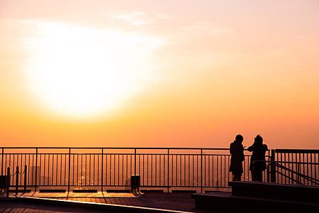 Due persone osservano il tramonto dalla terrazza di Roppongi Hills.