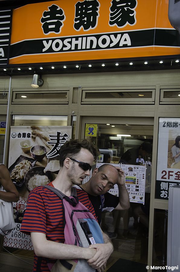 Marco Togni e un altro uomo in piedi davanti all'entrata del ristorante Yoshinoya a Tokyo.