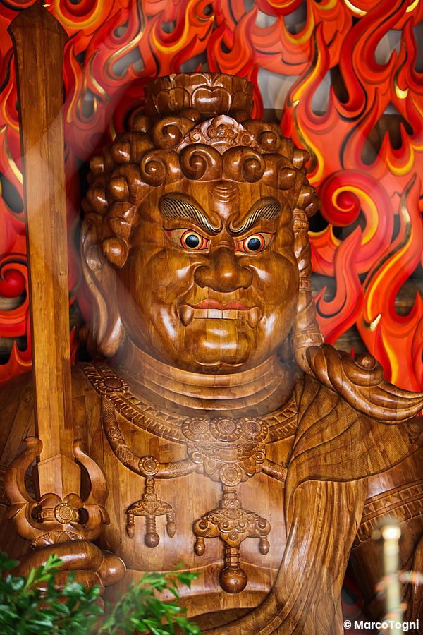 Statua di una divinità giapponese con sfondo fiammeggiante, a Hiroshima.