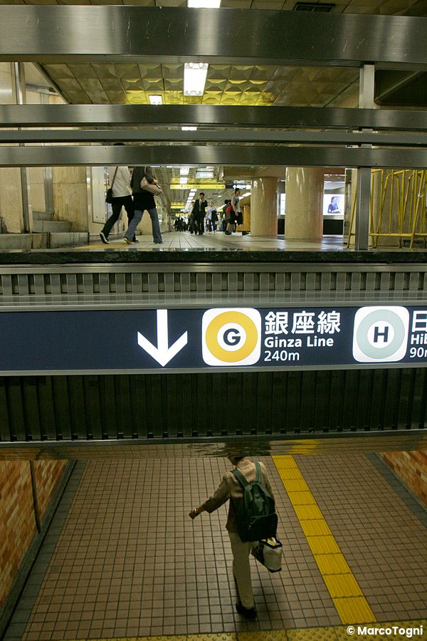 Persona che cammina nella stazione della metropolitana con segnale ginza line