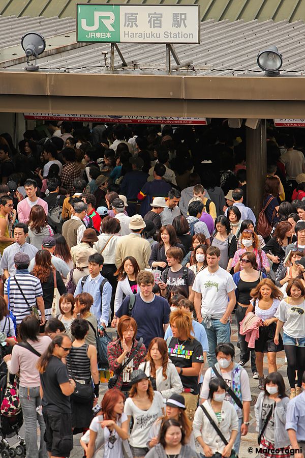 Una folla di persone cammina davanti all'ingresso della stazione Harajuku a Tokyo, in Giappone.