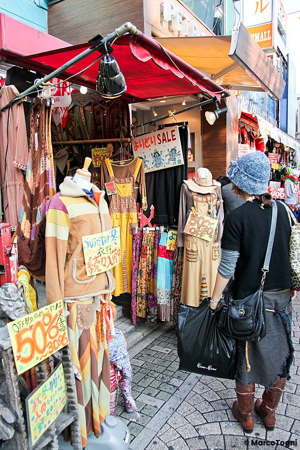 Una persona osserva le vetrine di un negozio di abbigliamento lungo la strada Takeshita Dori a Tokyo.