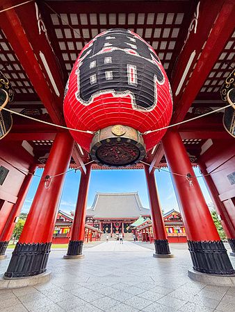 Lanterna rossa al tempio Senso-ji di Asakusa, Tokyo, con pilastri rossi e fondo blu.