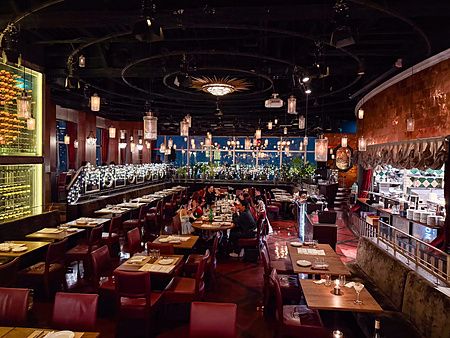 Veduta panoramica dell'interno del ristorante Cafe Legato a Shibuya con tavoli, sedie e luci soffuse.