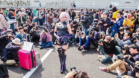 Una donna in costume da cosplay posa al centro di un gruppo di fotografi durante il Tokyo Game Show a Tokyo.