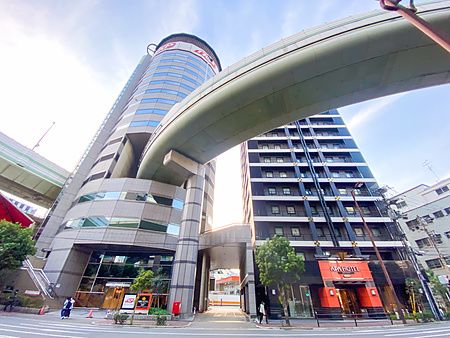 Veduta dal basso del Gate Tower Building a Osaka, con un'autostrada che attraversa la struttura dell'edificio.