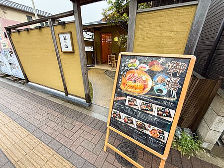 Cartellone pubblicitario con menu e ingresso al ristorante Waunn ad Asakusa.