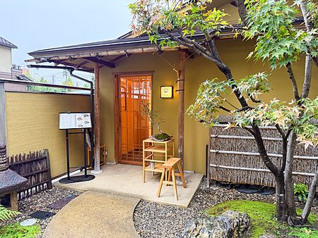 L'ingresso a Waunn, ristorante giapponese ad Asakusa, caratterizzato da una porta in legno e un giardino zen.