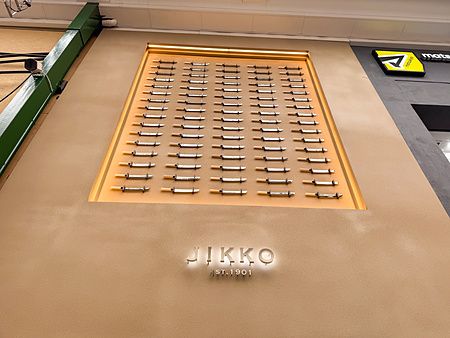 L'insegna all'esterno a Jikko a Osaka mostra una vetrina a muro con file di coltelli esposti sopra il logo.