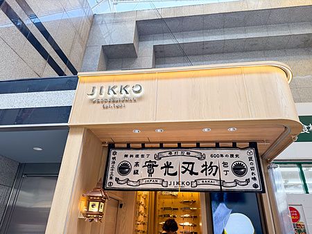 Facciata del negozio Jikko a Sennichimae Doguyasuji Shotengai, strada di Osaka, con noren tradizionale e coltelli esposti.