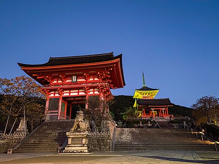 Tempio Kiyomizudera a Kyoto al crepuscolo con luci calde e scalinate.