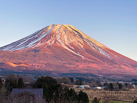 Monte Fuji al tramonto con case in primo piano.