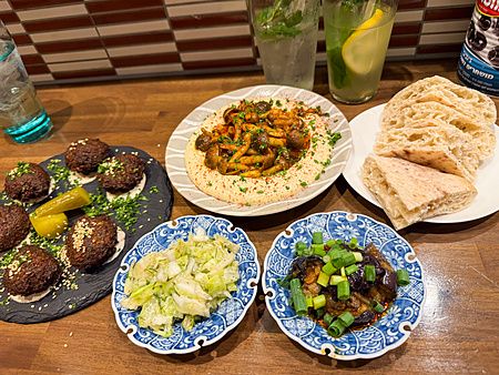 Piatti mediorientali al ristorante Telaviv a Kyoto, con falafel e hummus su un tavolo di legno.