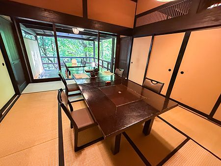 Una stanza privata dove mangiare presso il ristorante Kurochaya con pavimenti in tatami e vista sulla natura.