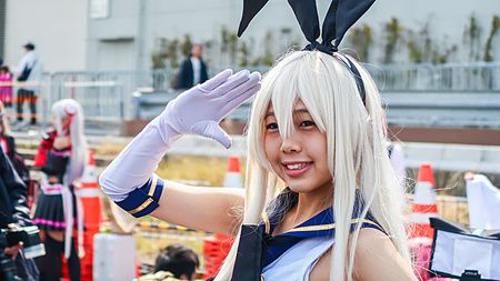 Persona in cosplay con costume elaborato e parrucca bionda.