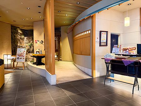 L'ingresso a Ume no Hana nel quartiere di Ginza a Tokyo con pavimentazione in pietra, elementi in legno e cascata.