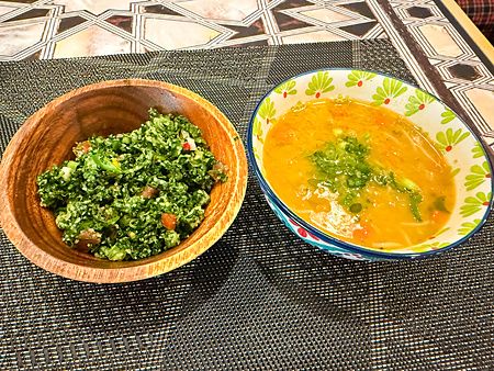 Una ciotola in legno con verdure e una in ceramica con zuppa servite presso il ristorante Seven Hills ad Osaka.