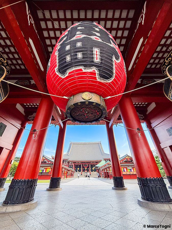 Lanterna rossa al tempio Senso-ji di Asakusa, Tokyo, con pilastri rossi e fondo blu.