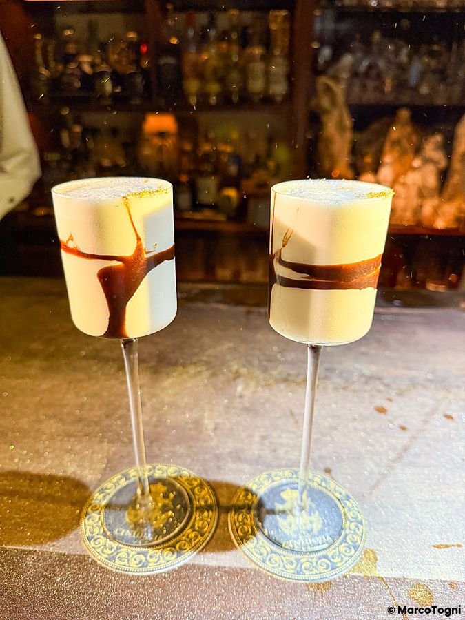 Due cocktail cremosi in bicchieri alti su sottobicchieri decorati all'interno del Bar Centifolia a Tokyo.