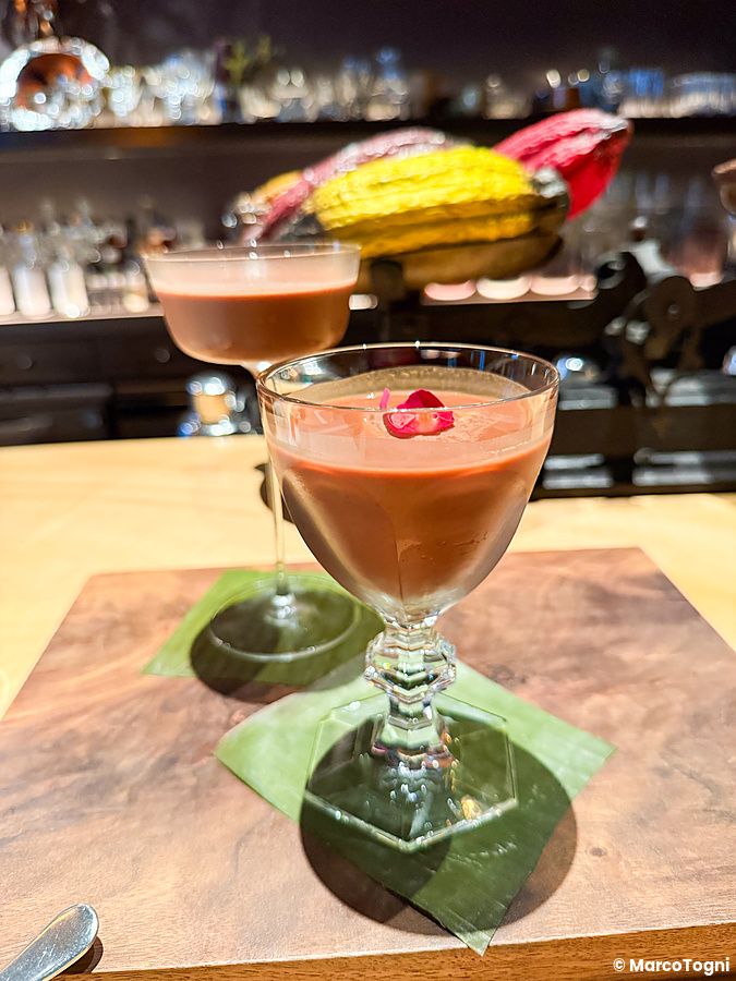 Due cocktail a base di cacao in calici eleganti su un tagliere di legno presso il bar Memento Mori a Tokyo.