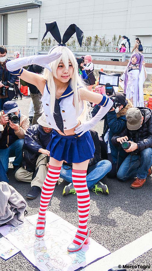 Individuo in cosplay con abito da coniglio circondato da fotografi.