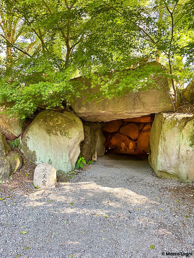 Ingresso di una grotta rocciosa naturale immersa nel verde presso la Daio Wasabi Farm a Matsumoto.