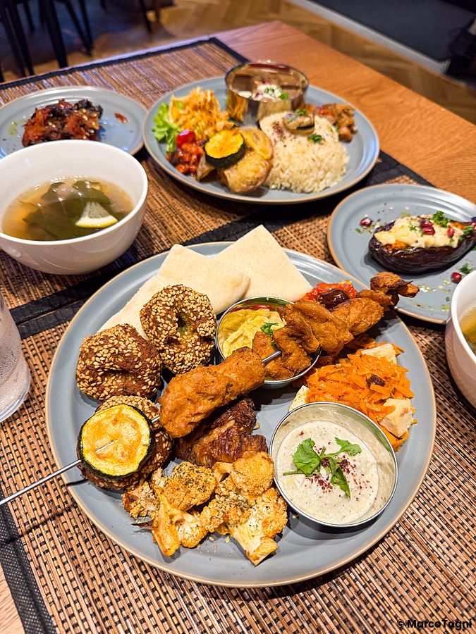 Un assortimento di piatti vegani serviti su vassoi al ristorante VeganLife SoiSoi.