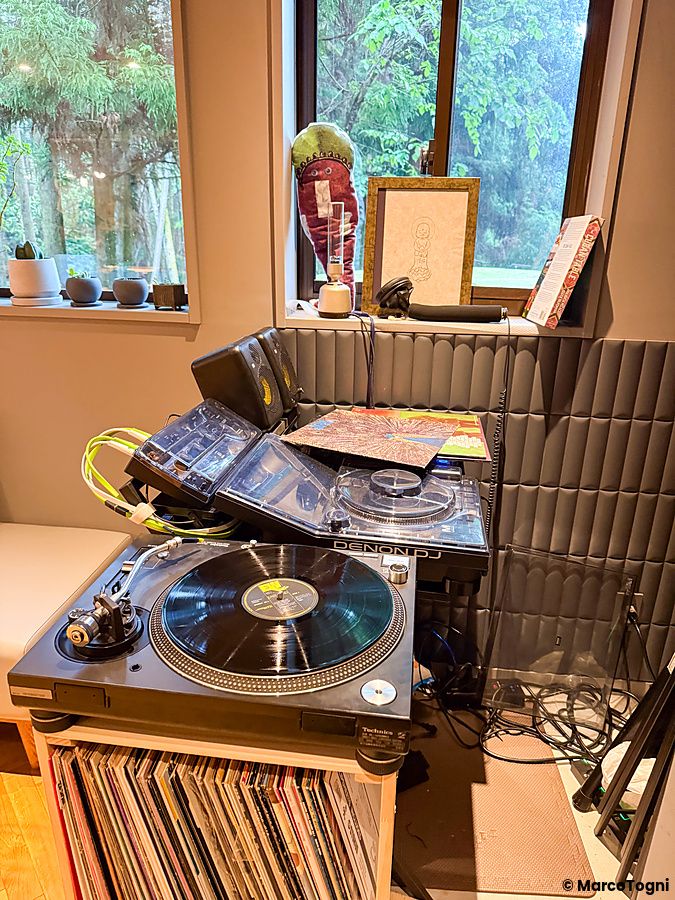 Dettaglio all'interno a VeganLife SoiSoi con giradischi Technics e console Denon DJ posizionati vicino a una finestra.