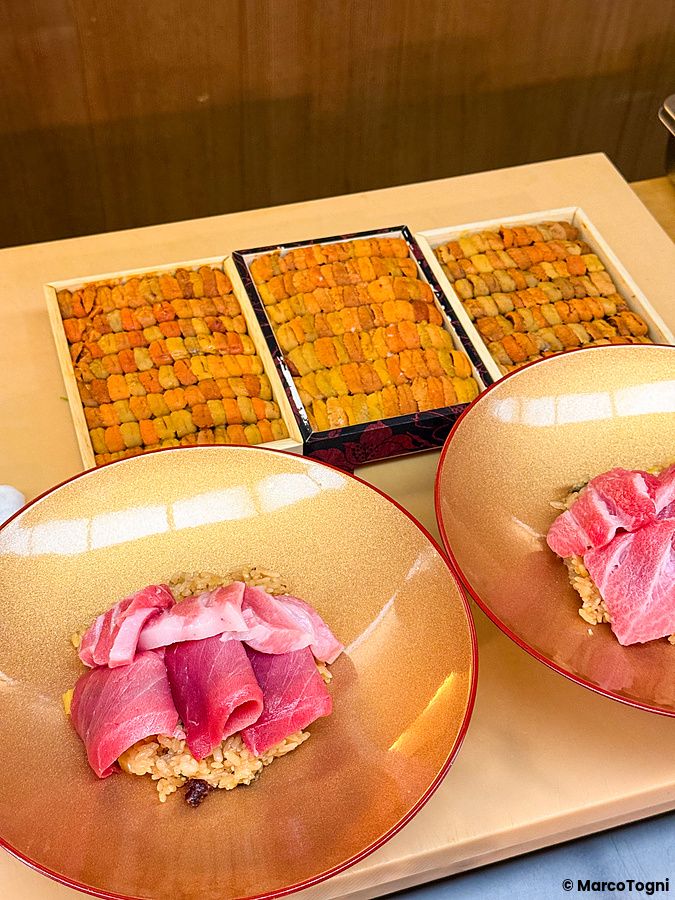 Uno chef prepara un donburi premium con riccio di mare, otoro, chutoro e ikura all'interno del ristorante Waunn.