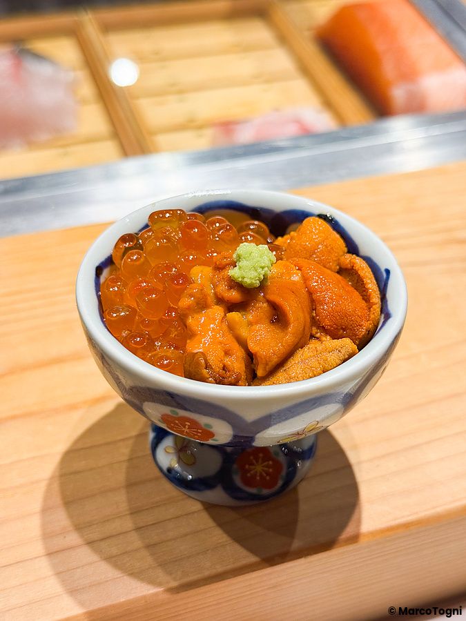 Un mini donburi con ikura e riccio di mare servito in una piccola ciotola al Sushi & Bar Fujiro Marunouchi Tokyo.