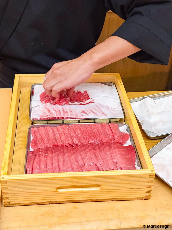 Uno chef al lavoro prepara un donburi premium con otoro e chutoro presso il ristorante Waunn ad Asakusa.