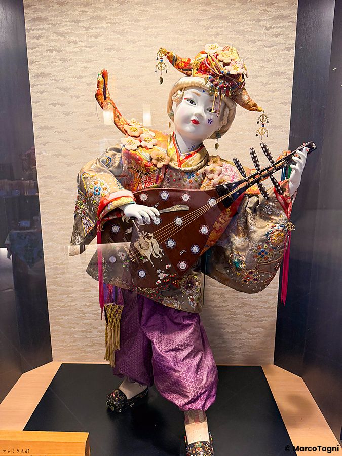 Dettaglio a Ume no Hana a Ginza che mostra una bambola tradizionale giapponese finemente vestita con uno strumento.