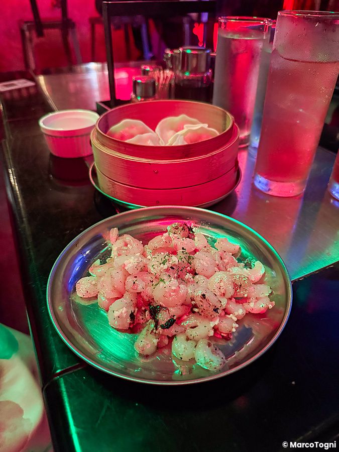 Gamberetti vegani serviti su un piatto metallico in un ristorante in stile cyberpunk chiamato Neo Shinjuku Atsushi.