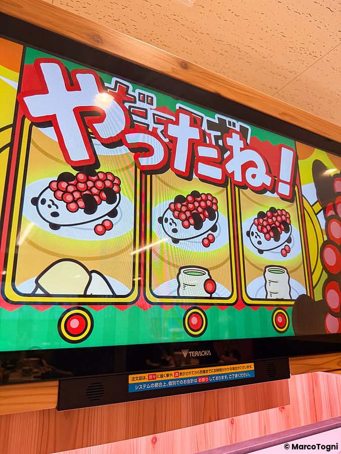 Uno schermo interattivo di un gioco presso Sushiro che mostra icone di panda e testo celebrativo per una vincita.