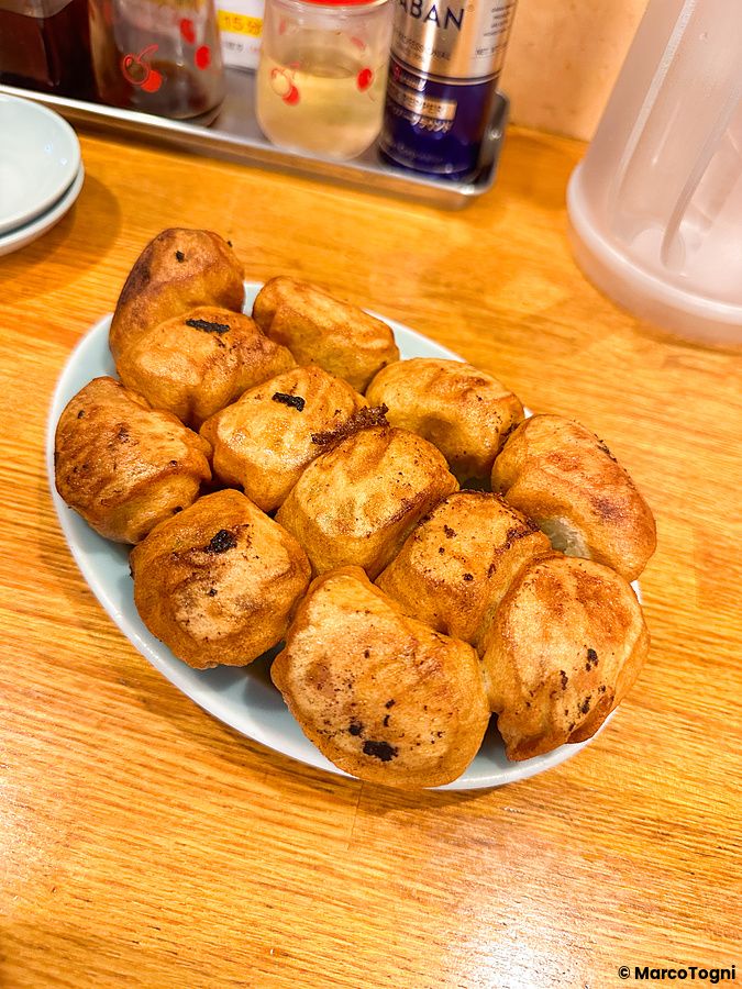 Piatto ovale con gyoza dorati al ristorante Fight Gyoza nel quartiere Otsuka a Tokyo.