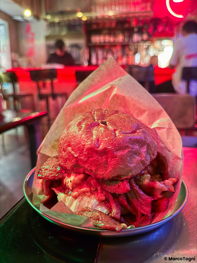 Un hamburger vegano in carta alimentare su un piatto metallico all'interno del ristorante Neo Shinjuku Atsushi a Shinjuku.
