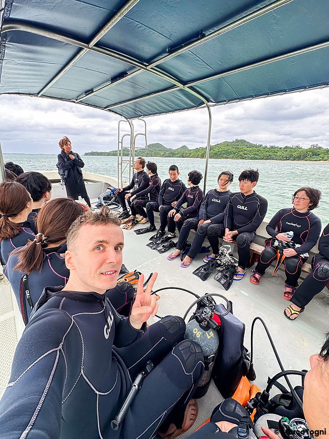Marco Togni e altri individui in mute su una barca a Ishigaki, pronti per un'immersione