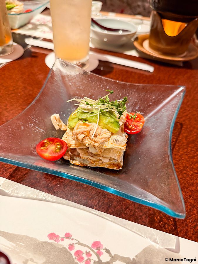 Insalata con yuba, avocado e verdure servita in un piatto di vetro blu presso il ristorante Ume no Hana a Ginza.
