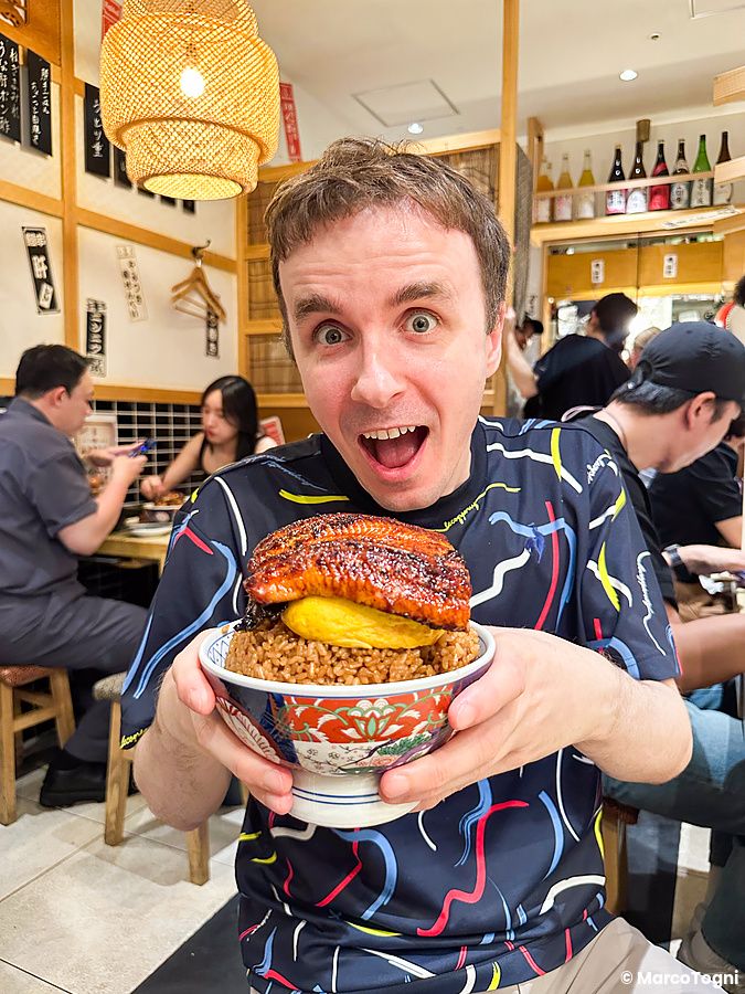 Marco Togni mostra una ciotola di riso con unagi all'interno del ristorante Izumo ad Osaka.