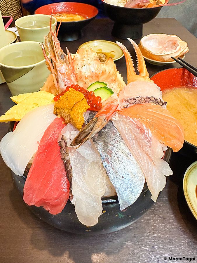 Una ricca ciotola di kaisendon con pesce crudo, granchio e gamberi servita presso il ristorante Kaisendon Ichiba.
