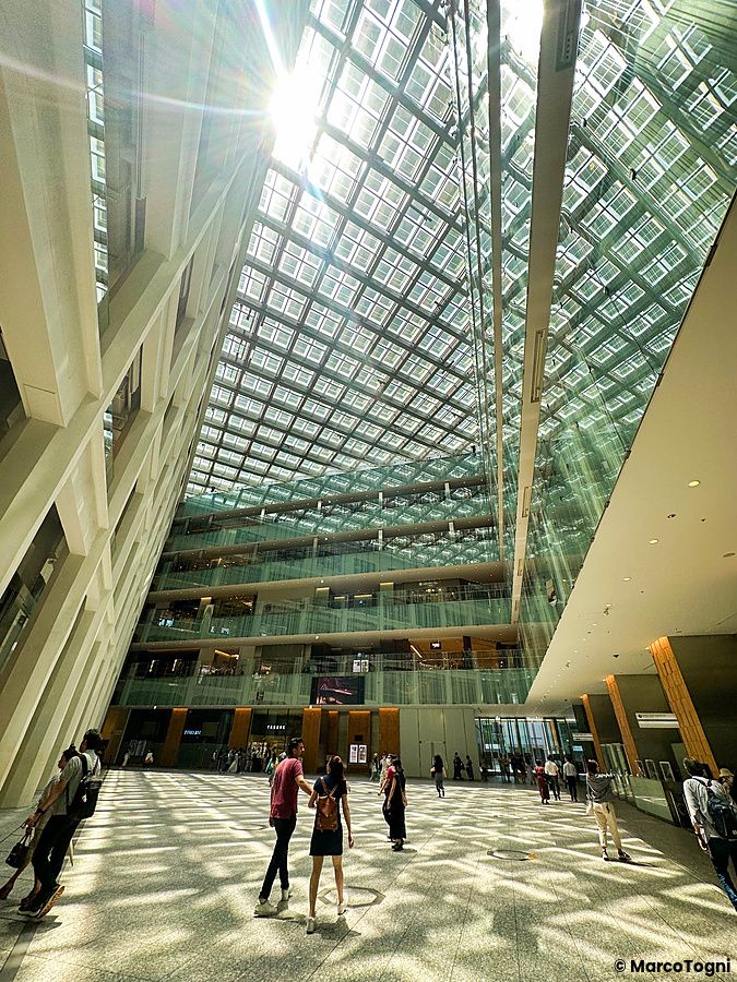 L'atrio interno del centro commerciale Kitte a Marunouchi, con persone che camminano sotto una grande copertura vetrata.