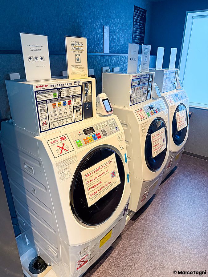 Tre lavatrici Sharp in fila all'interno del JR East Hotel Mets Premier Akihabara di Tokyo.