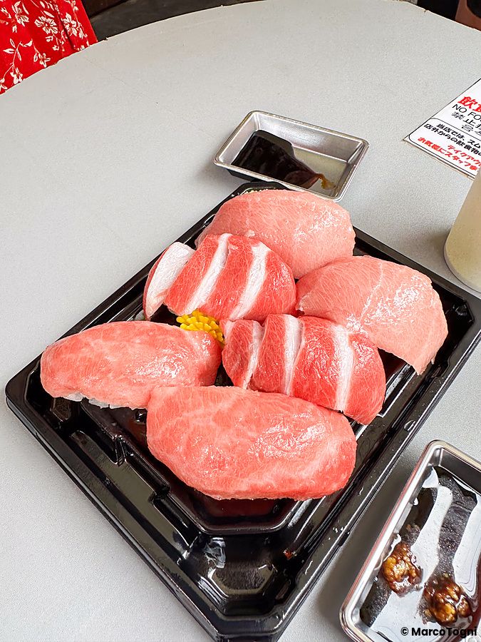 Una selezione di vari sushi di tonno a Maguroya Kurogin servita su un vassoio di plastica nero al mercato di Tsukiji.